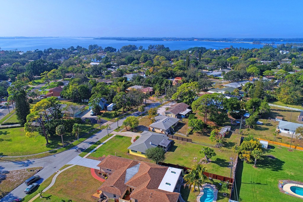 A bird's eye view of a residential area with houses and a swimming pool.