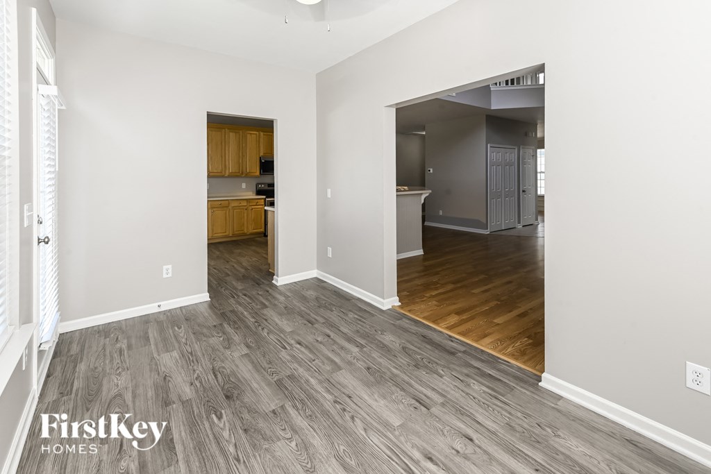 a renovated living room and kitchen with wood floors and white walls