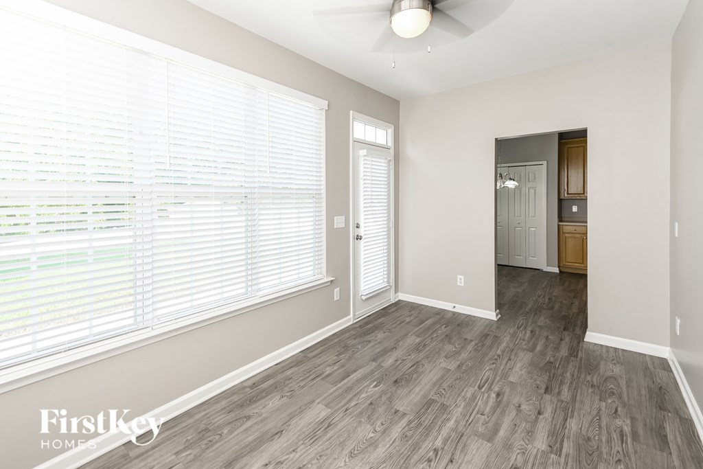 an empty living room with a large window and wood flooring