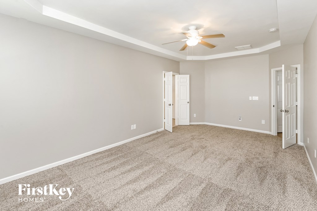 a empty room with a ceiling fan and a door to a closet