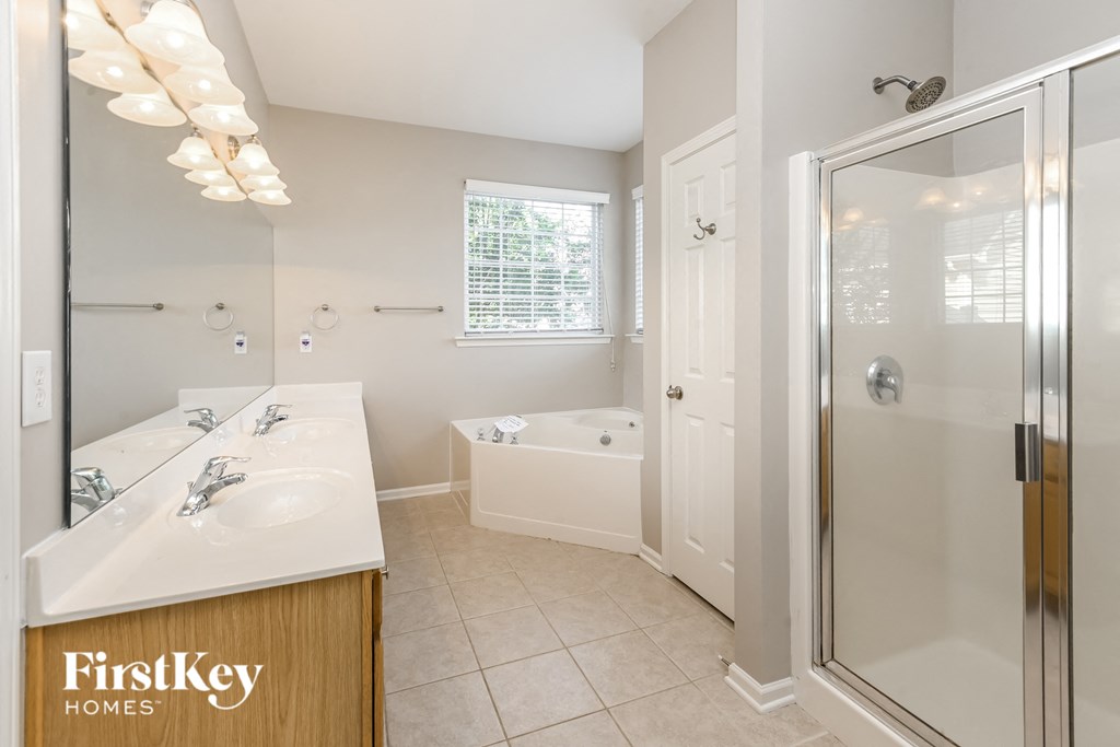 a bathroom with two sinks and a shower and a tub