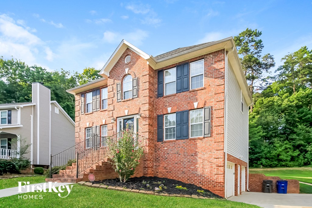 A brick house with a sign that says "First Key Homes".