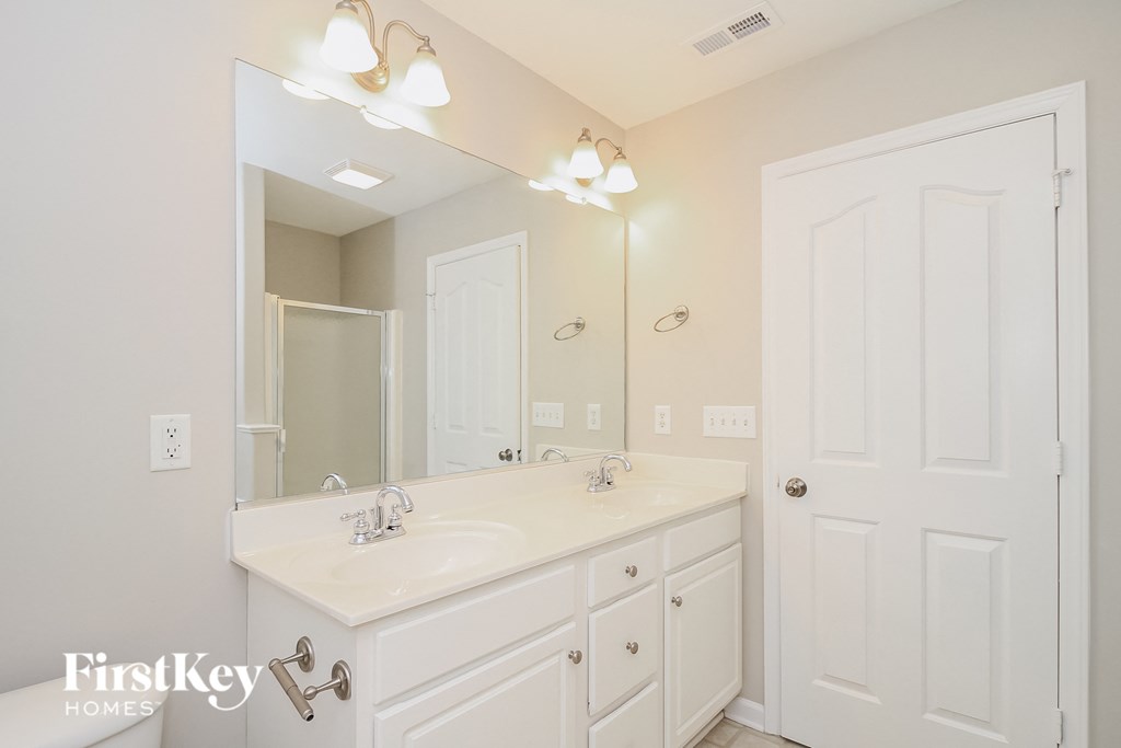 A bathroom with a white sink and a mirror above it.