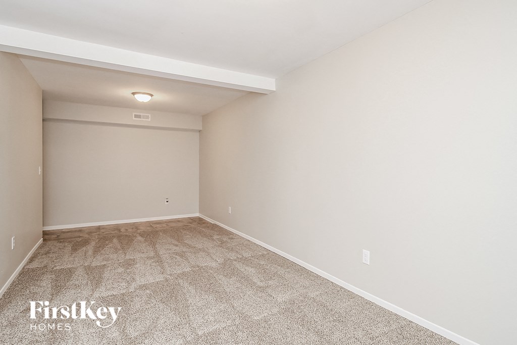 A room with a carpeted floor and a FirstKey Homes logo.