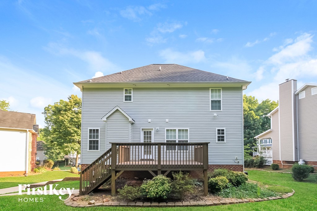 A house with a grey exterior and a wooden deck.