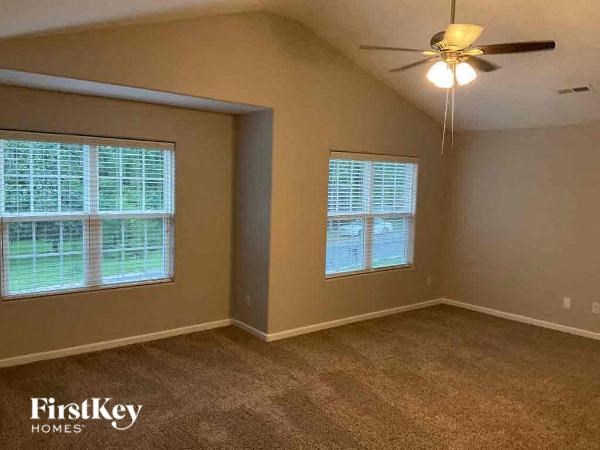 an empty bedroom with a ceiling fan and a window