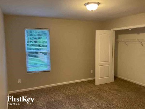 an empty room with a window and a closet