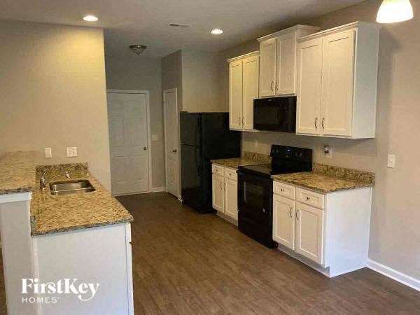 a kitchen with white cabinets and black appliances