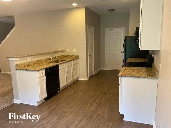 a kitchen with white cabinets and granite counter tops