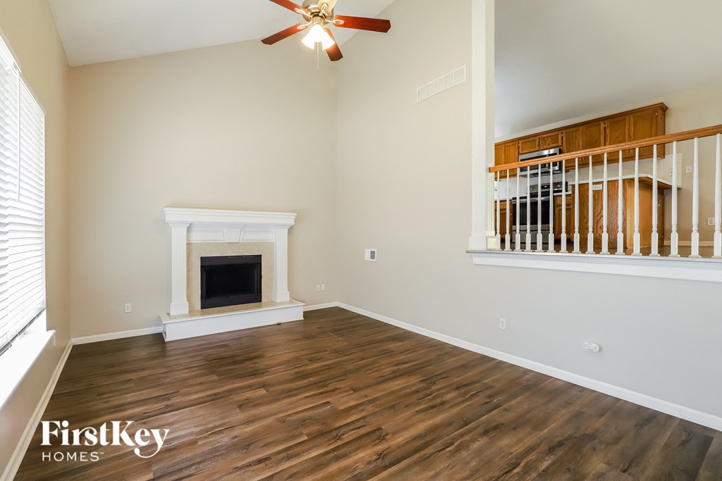 the living room has a fireplace and hardwood flooring