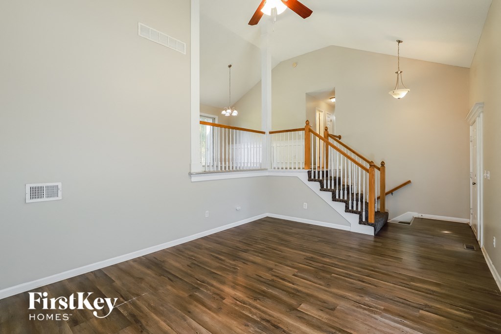 the great room with hardwood flooring and stairs to the upper level