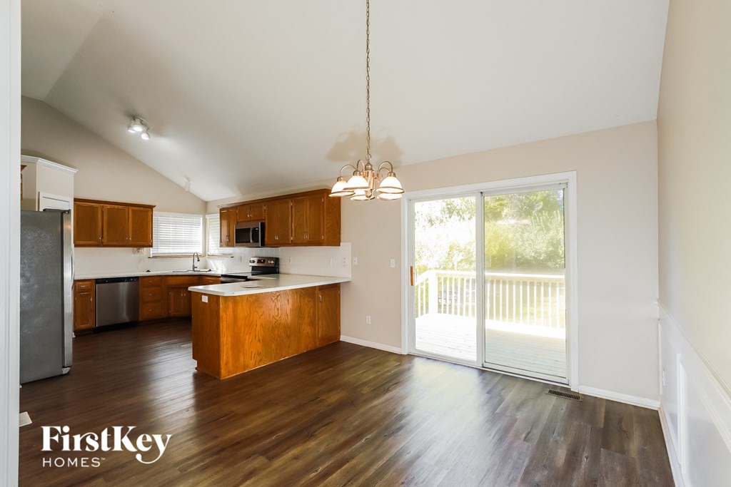 an empty kitchen with a sliding glass door to a balcony