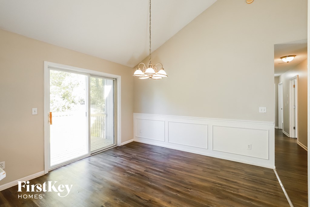 an empty living room with white walls and a sliding glass door