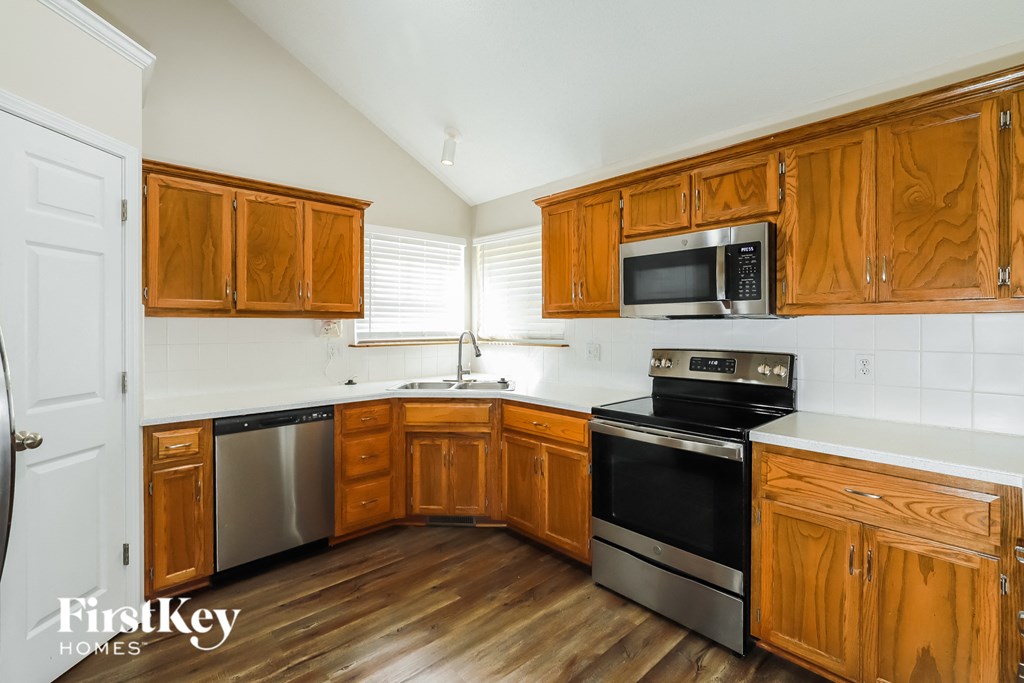 a kitchen with wooden cabinets and stainless steel appliances