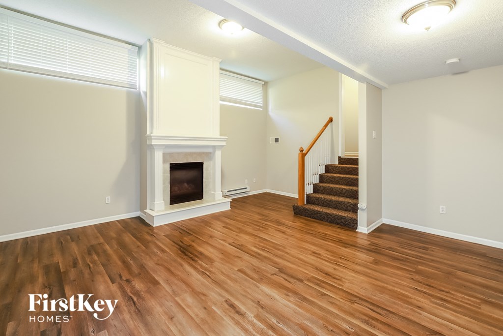 the living room with wood flooring and a fireplace