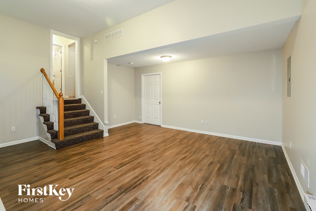 a living room with hardwood flooring and a staircase