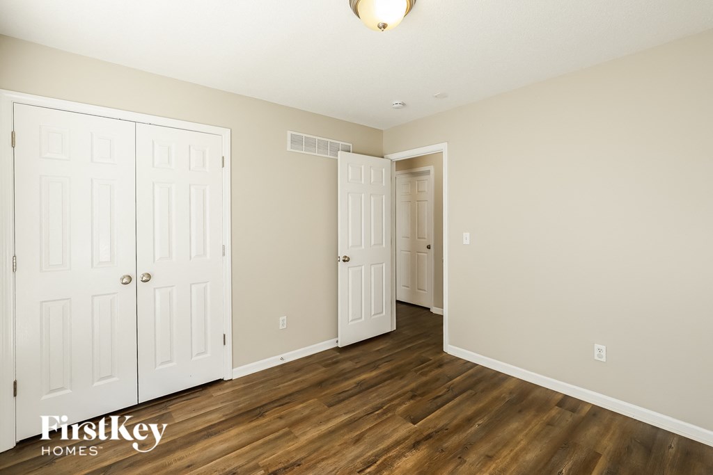a bedroom with two closets and a door to a hallway