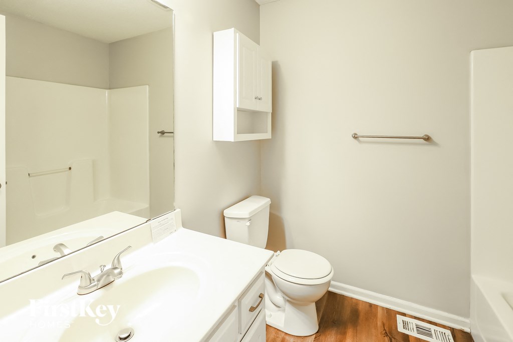 a bathroom with a sink toilet and a mirror