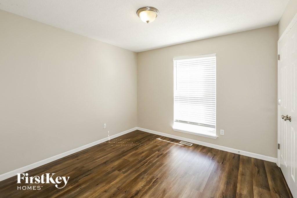 the living room of a house with wooden floors and a window