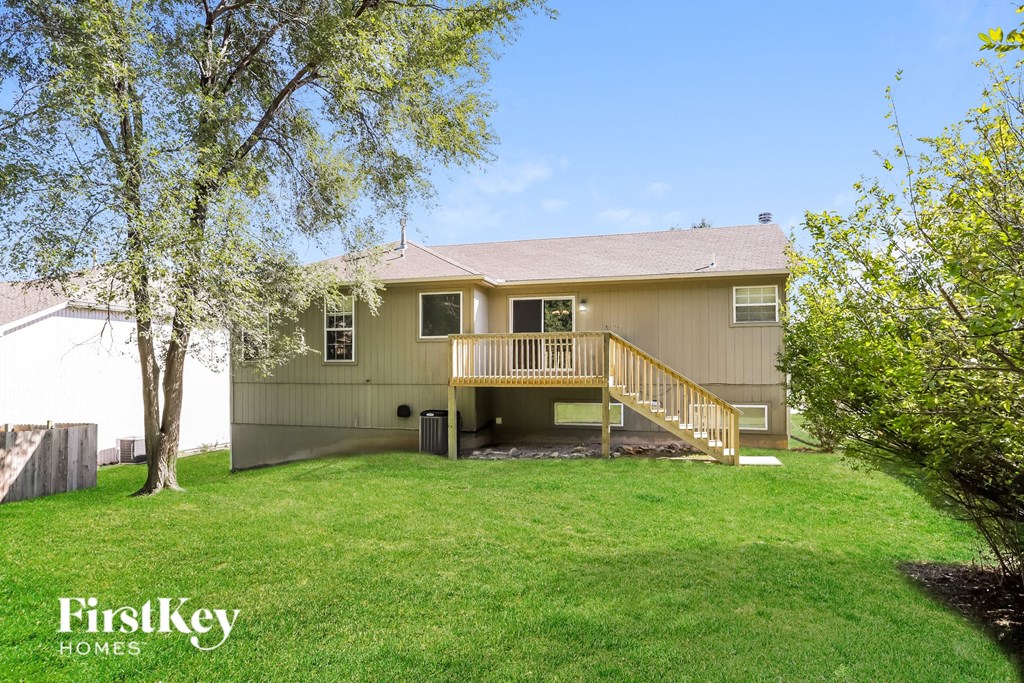 a backyard with a deck and a tree