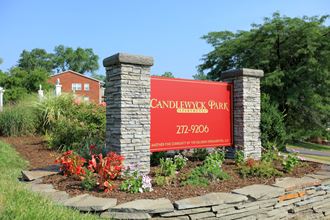 a sign for candlestick park in front of a stone wall and flowers