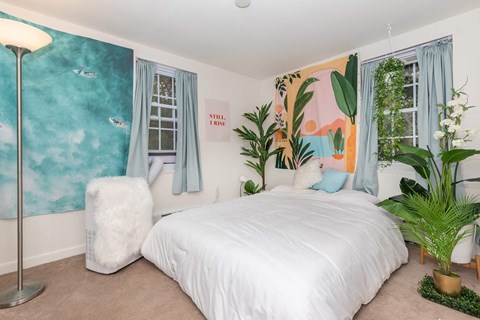 a bedroom with a bed and plants in it