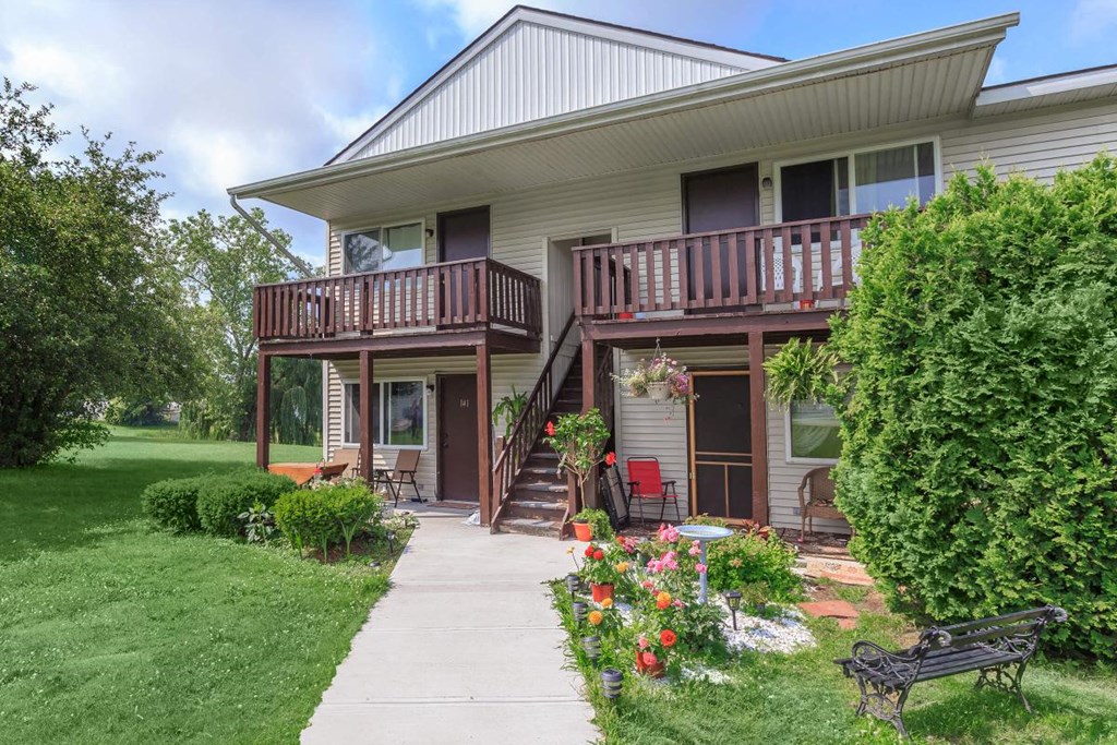 a house with a walkway and a bench in front of it