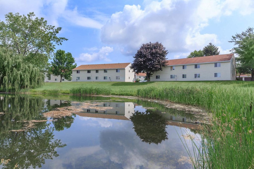the building in which the hotel is located is reflected in a pond