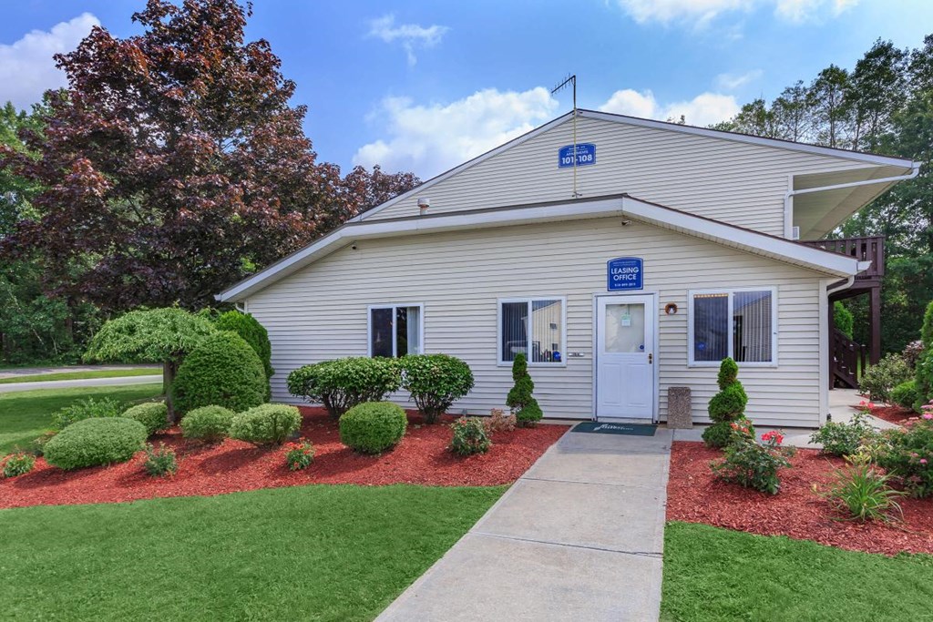the front of a white house with a sidewalk in front of it