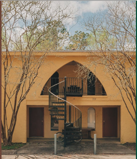 a building with a spiral staircase  and a tree