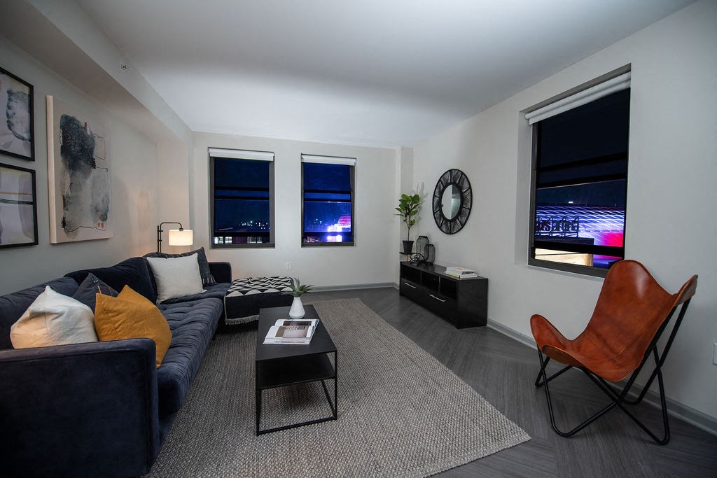 a living room with a blue couch and a brown chair