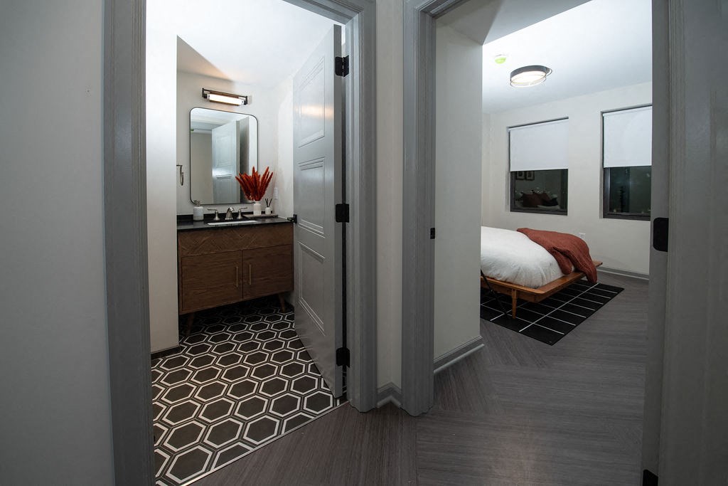 a view of a bedroom and a bathroom from the hallway