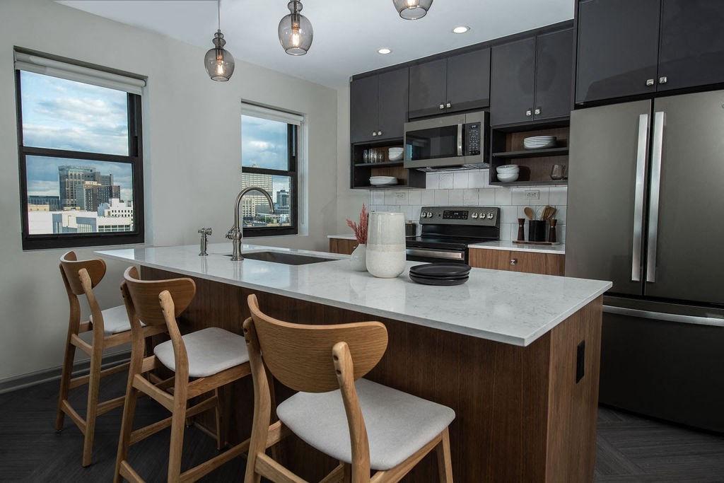 a kitchen with a marble counter top and wooden chairs