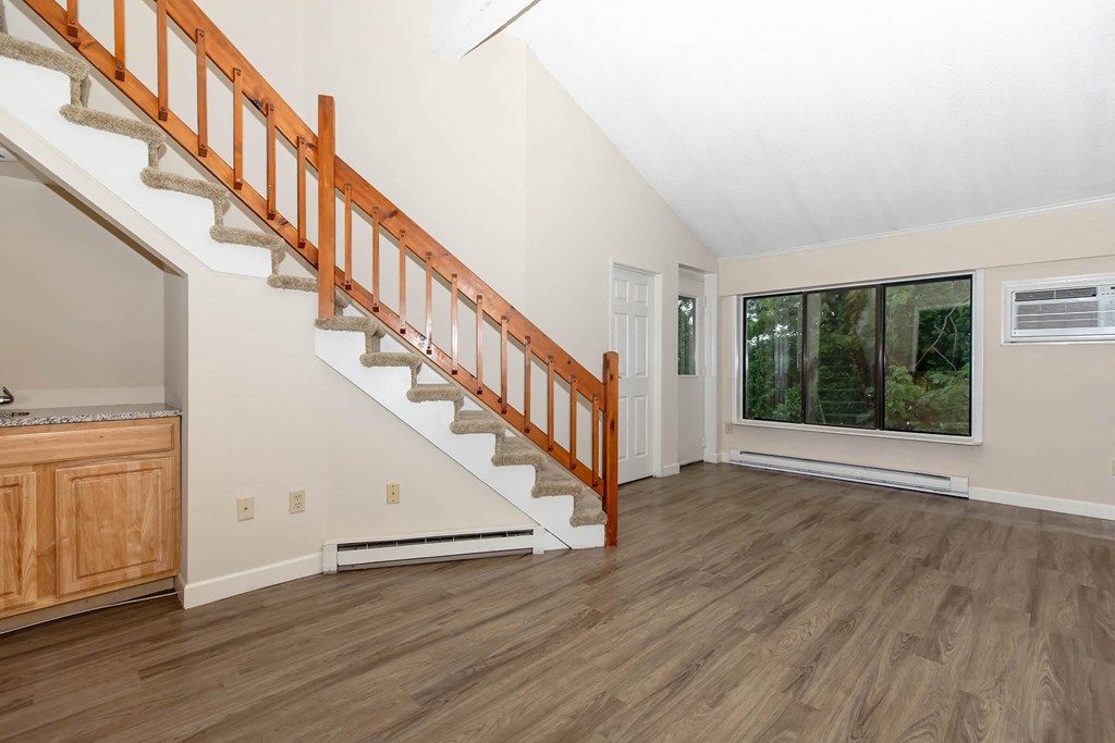 a living room with a staircase and a window