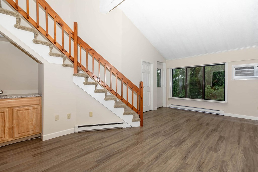 a living room with a staircase and a window