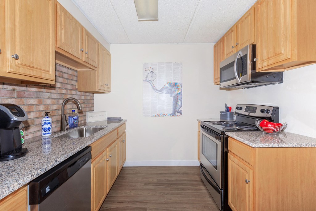 a kitchen with wood cabinets and granite counter tops and a sink