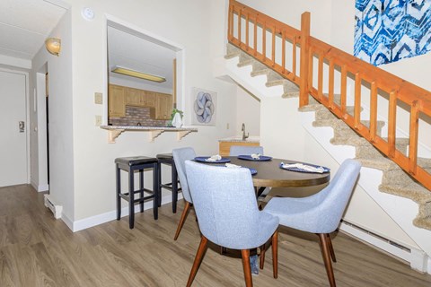 a dining room with a table and chairs and a staircase