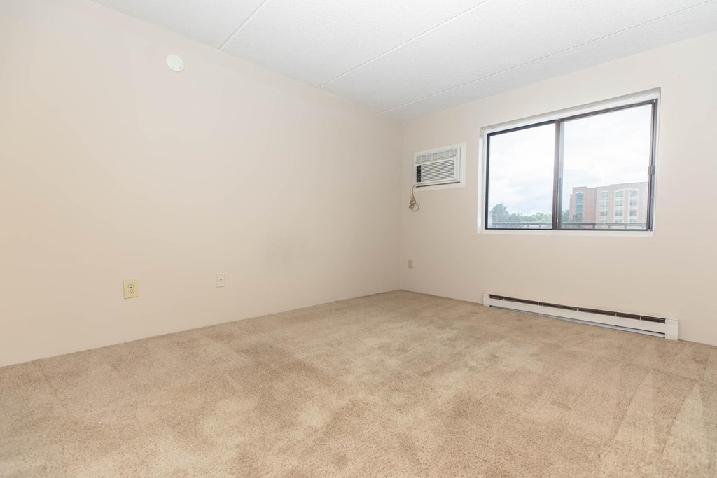 an empty room with a window and carpet