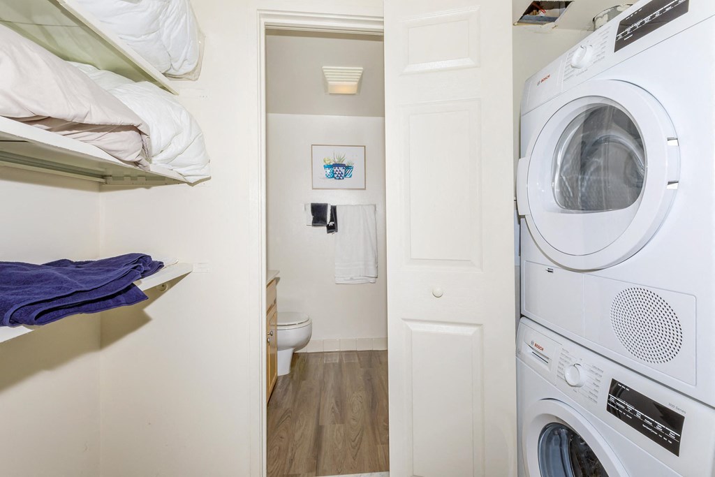 a small laundry room with a washer and dryer and a toilet