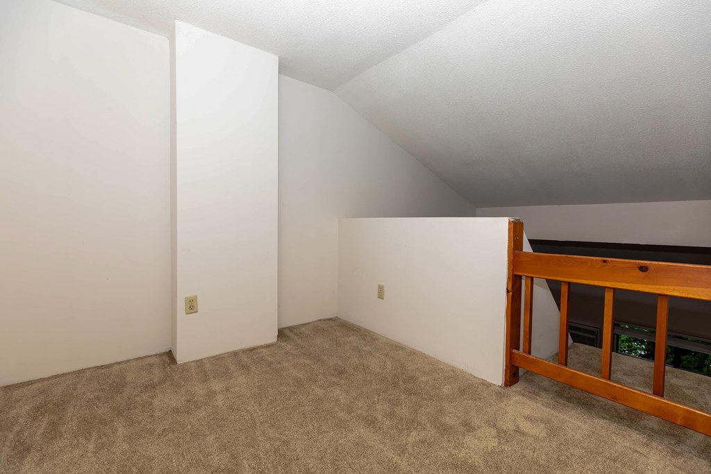 the upstairs bedroom has a loft with a bed and carpet