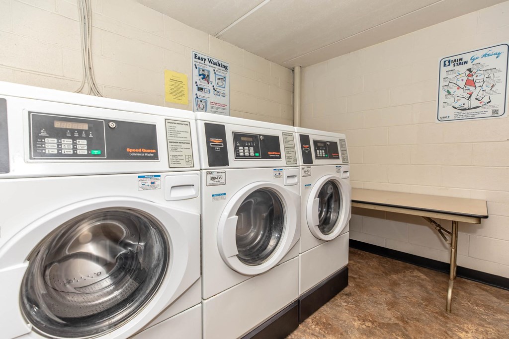 a washer and dryer in a laundry room with two washing machines
