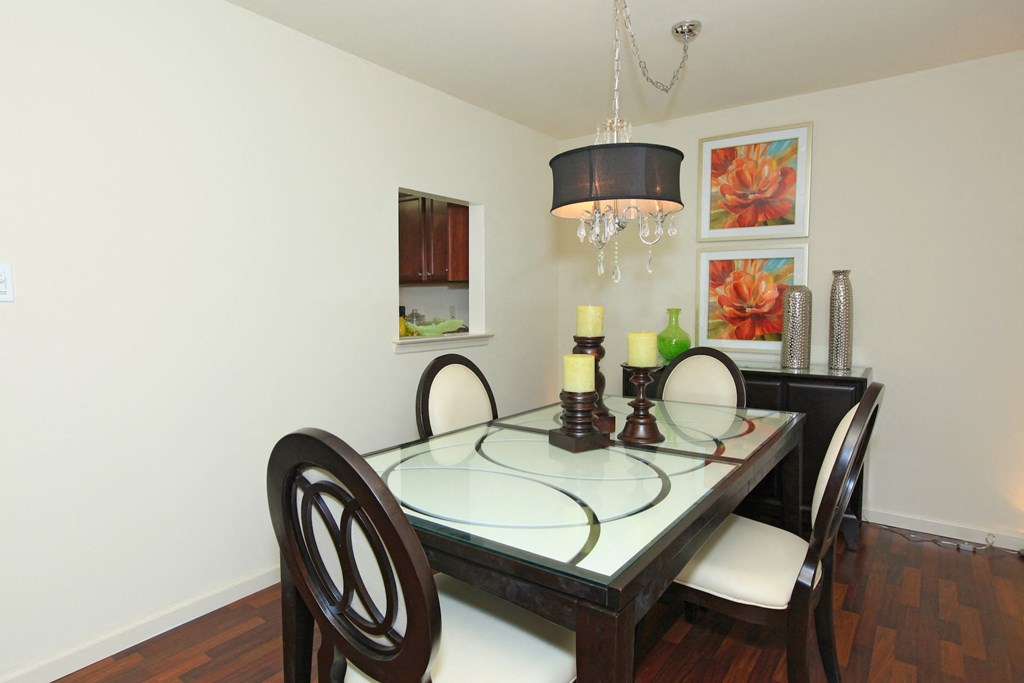 a dining room with a glass table and chairs and a chandelier