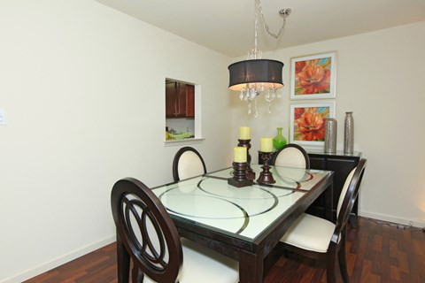 a dining room with a glass table and chairs and a chandelier