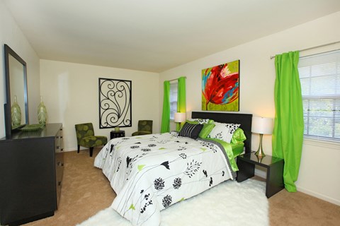 a bedroom with green curtains and a black and white bed
