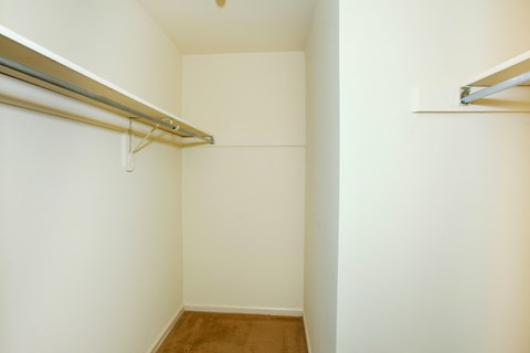 an empty room with a white wall and a hanging rail on the wall