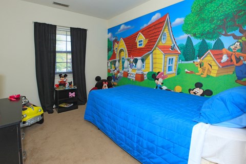 a bedroom with a mural on the wall and a bed