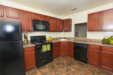 a kitchen with black appliances and wooden cabinets