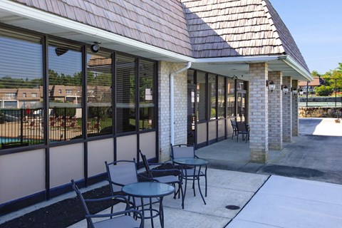 a patio with tables and chairs outside of a building