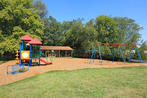 a playground with a swing set and a pavilion