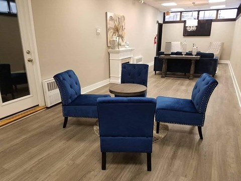 a waiting room with blue chairs and a table